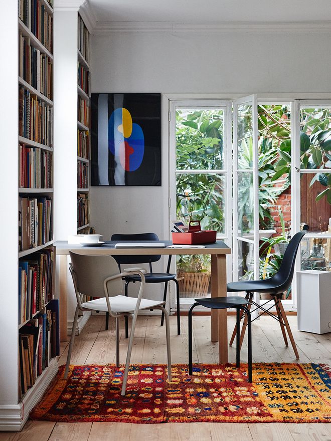 Artekin Lukki-tuoli ja Vitran Eames DSW -tuoli pöydän ääressä.