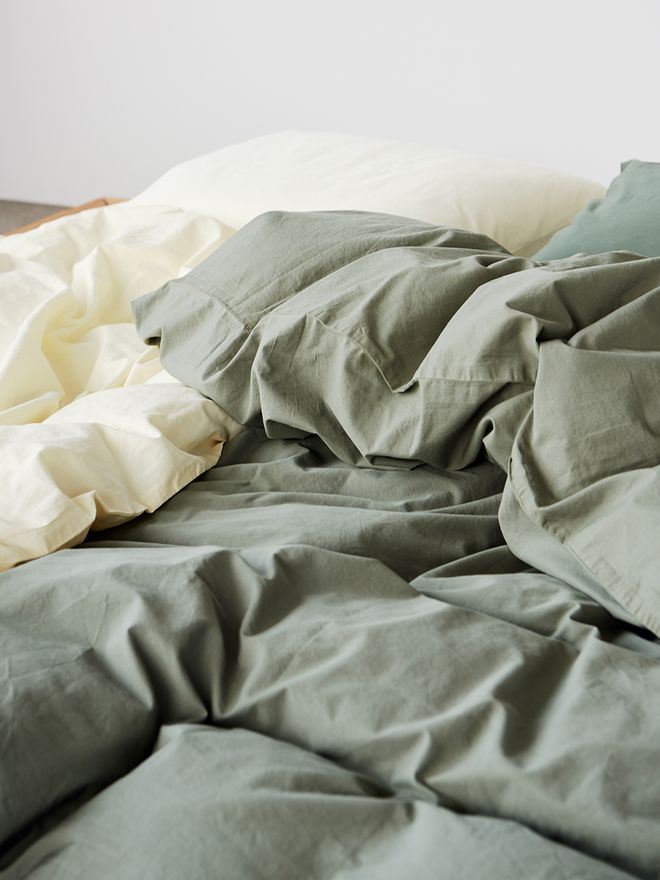 Tekla's Olive green duvet cover on a bed.