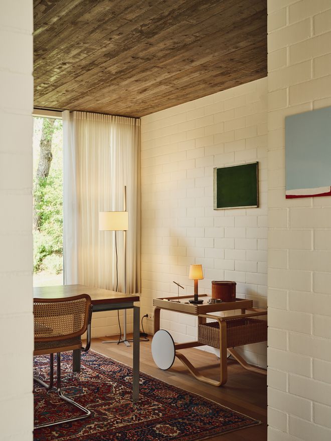 A dining space with a Santa & Cole lamp and an Artek trolley