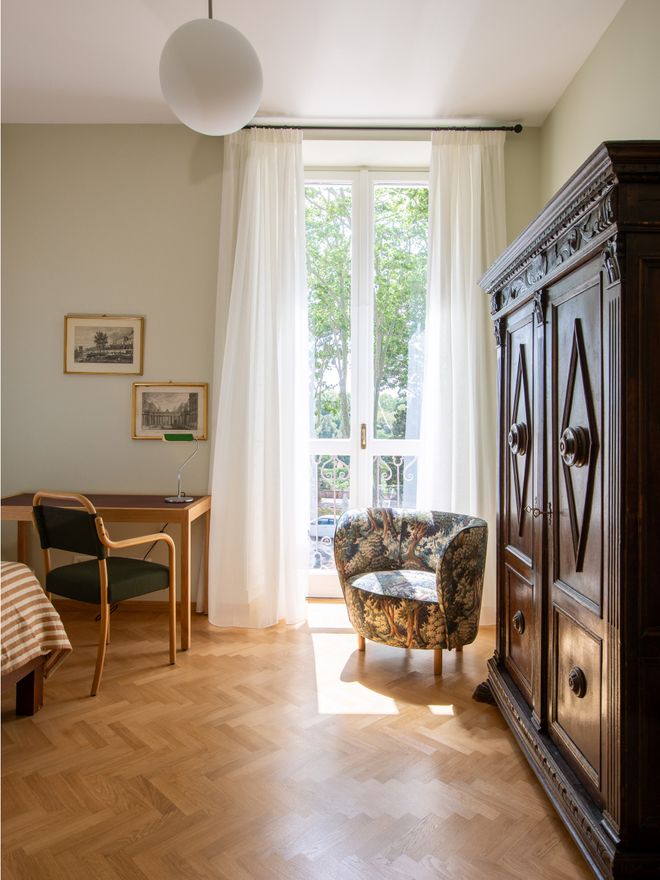 Interior of a Villa Lante guest room with an armchair and old cabinet
