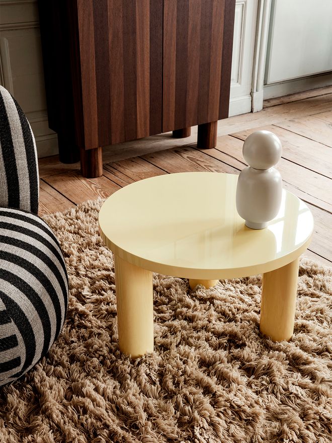 An image of ferm LIVING's yellow Post coffee table and wooden Post storage cabinet as part of the living room decor.