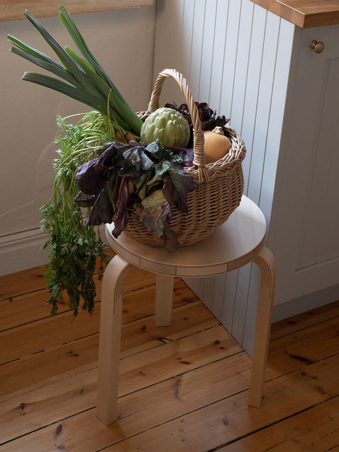 Artek Aalto stool 60 Kontrasti with a basket of vegetables on top