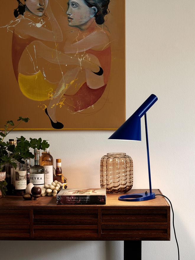 Louis Poulsen's AJ table lamp on a desk.