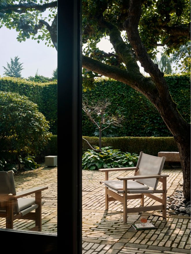 A garden chair placed on a terrace surrounded by lush trees