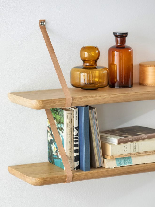 Two of Tapio Anttila's Renki shelves hanging on top of each other with small glass vases and books placed on them.