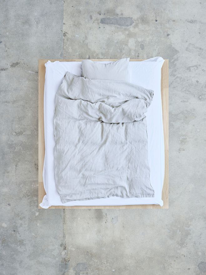 Tekla's light grey duvet cover and pillow sham styled on a bed.