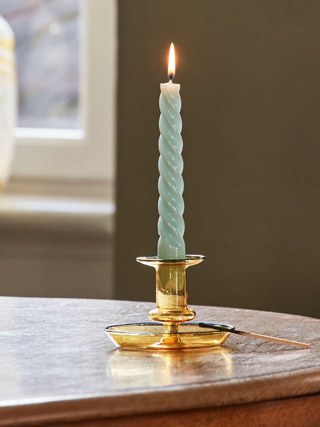 An image with HAY's mint green Twist candle and yellow Flare candleholder as part of a festive decor.