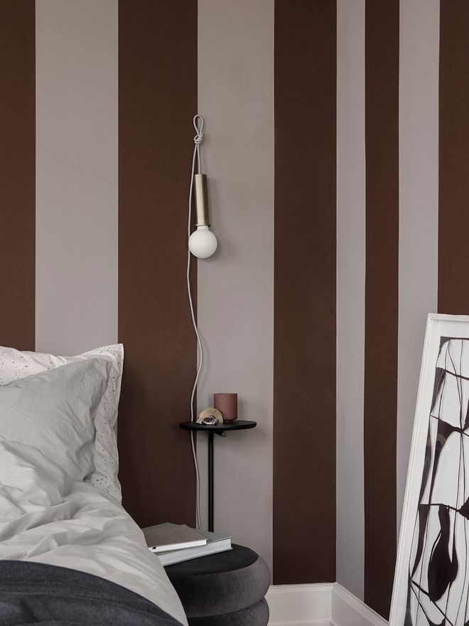 Ferm Living's Socket Pendant hung up on the wall in a bedroom.
