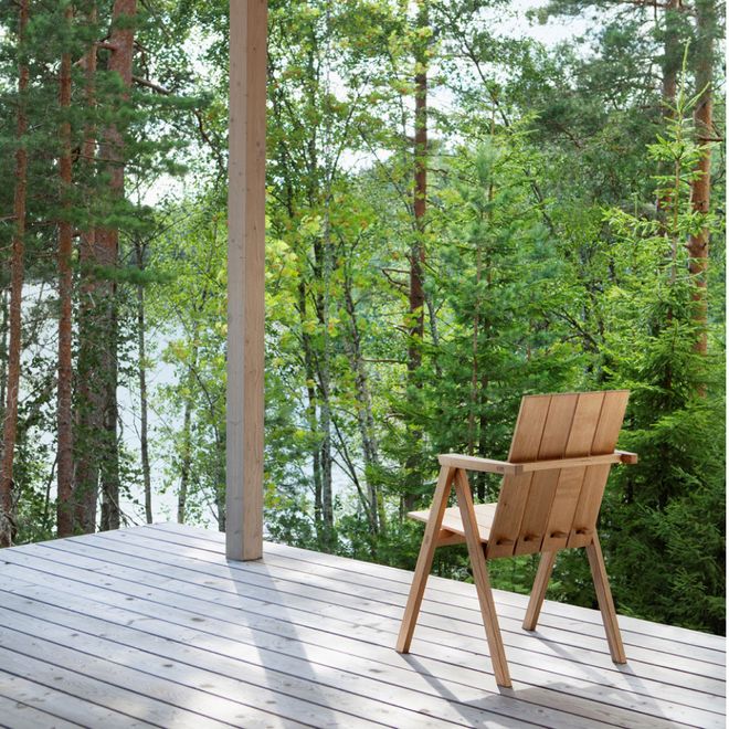 Nikari’s Arkipelago chair on a wooden deck surrounded by a forest