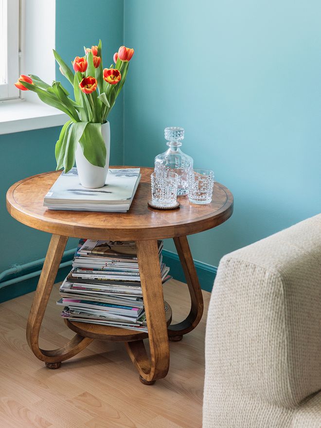 An antique side table with tulips in a vase