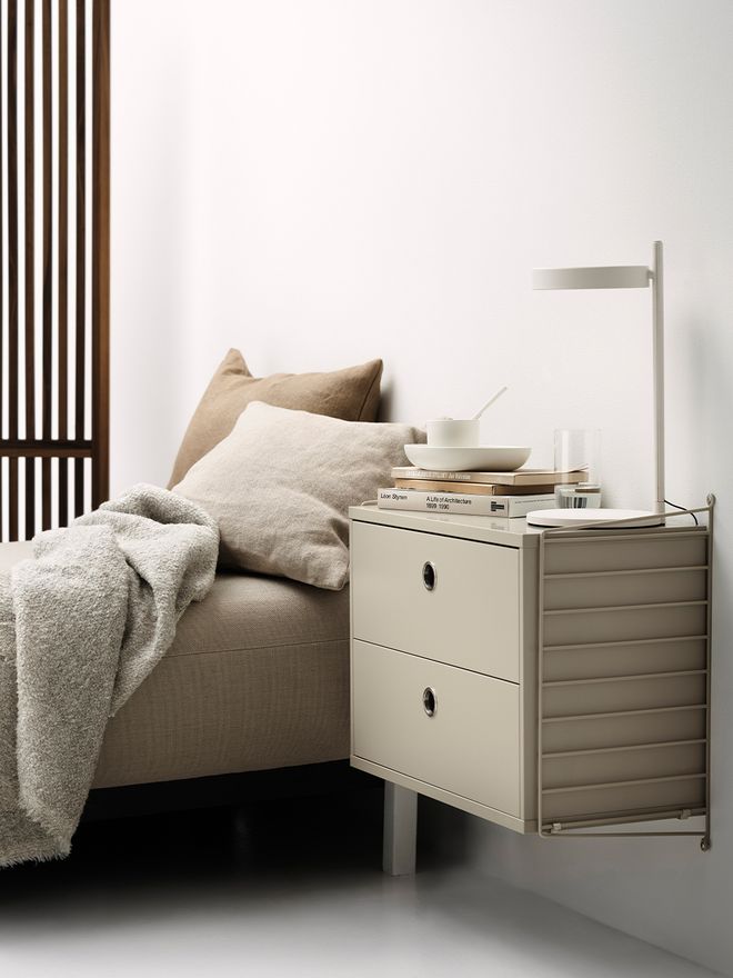 Kuva, jossa String Furnituren String System -seinälaatikosto osana makuuhuoneen sisustusta.