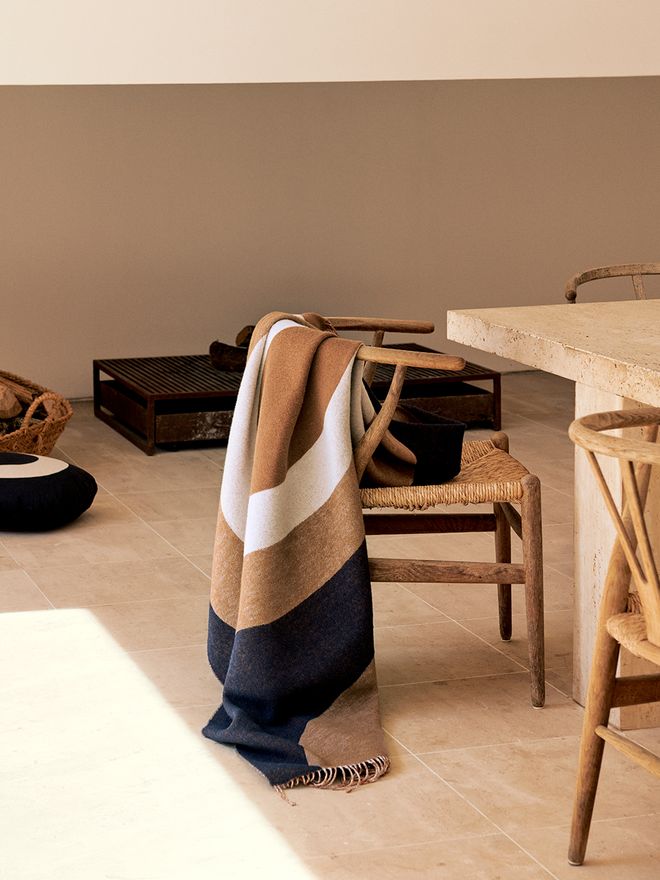 An image with Marimekko's Melooni throw on a chair backrest, as part of the decor.