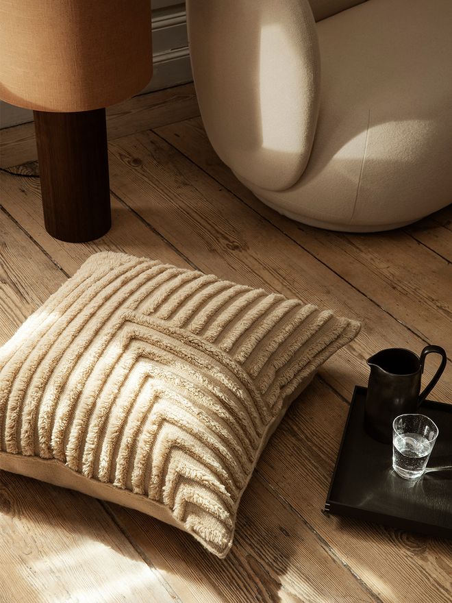 Ferm Living's Crease wool floor cushion on the floor.