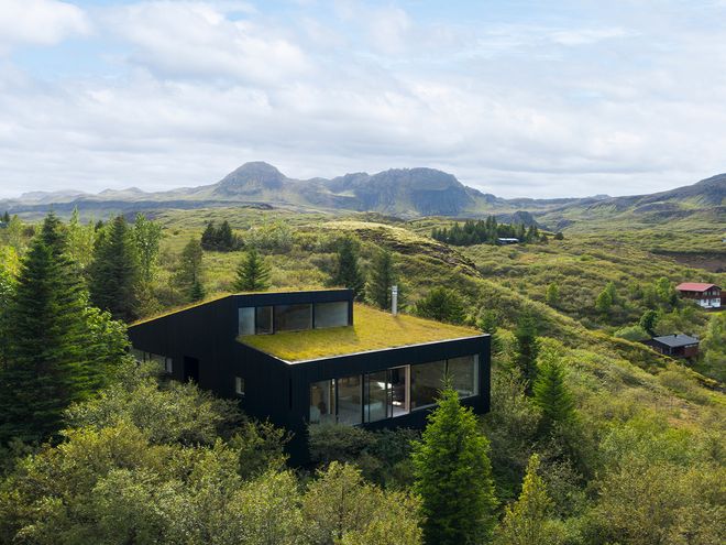 An image of the Holiday home by Þingvallavatn by KRADS architects: a leisure home located in Iceland in the middle of a picturesque scenery. This image features the building as viewed from the outside.