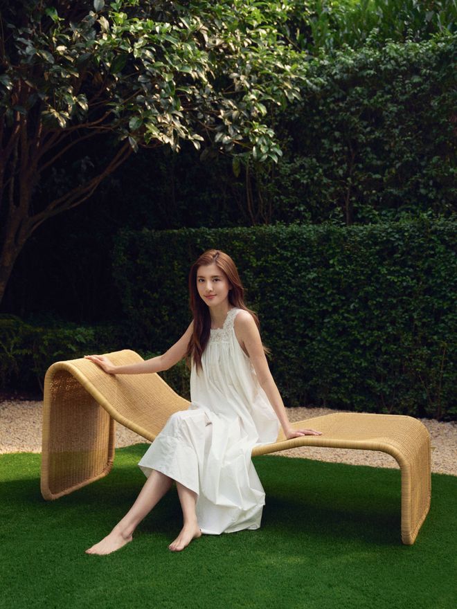 Karena Ng sitting on a P3S Outdoor chaise longue in her lush garden