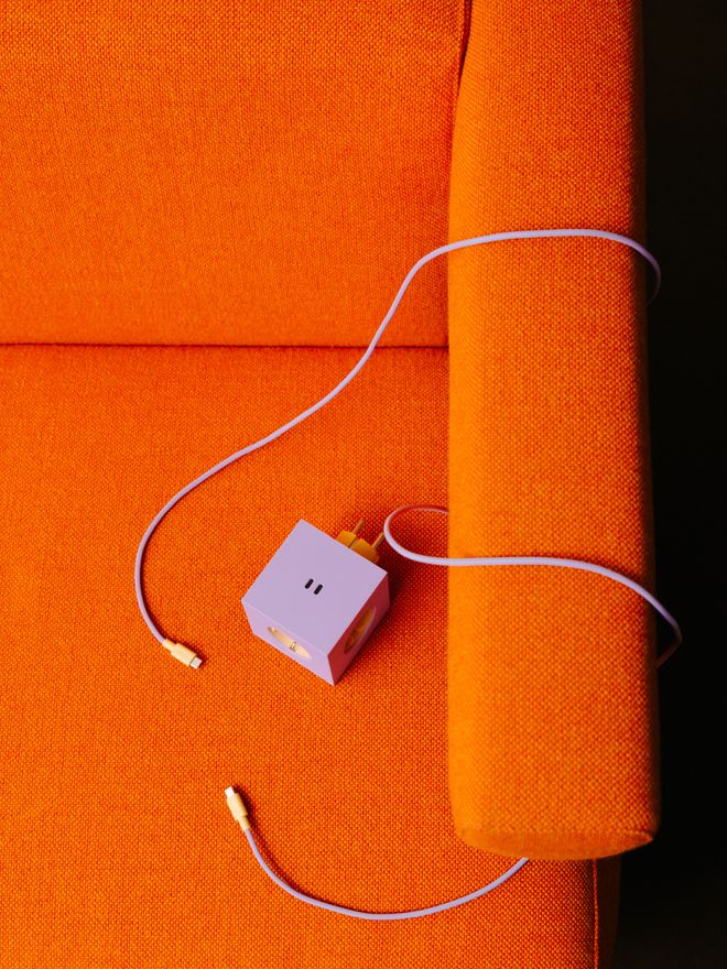 Close-up of Avolt's Square 1 extension cord on a colorful sofa