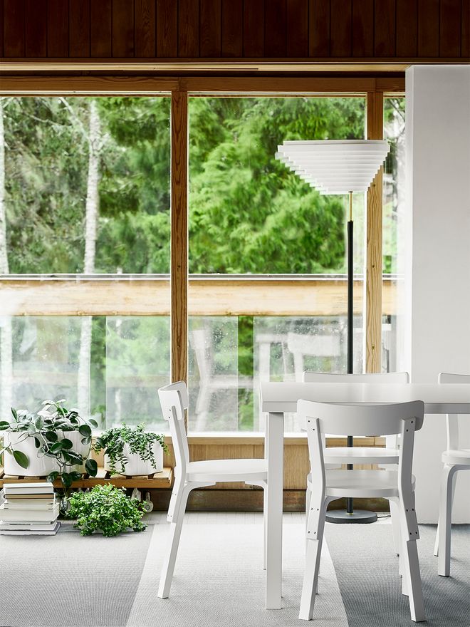 An image featuring Artek's Aalto chair 69 and A805 floor lamp beside a dining table, as part of the dining room decor.