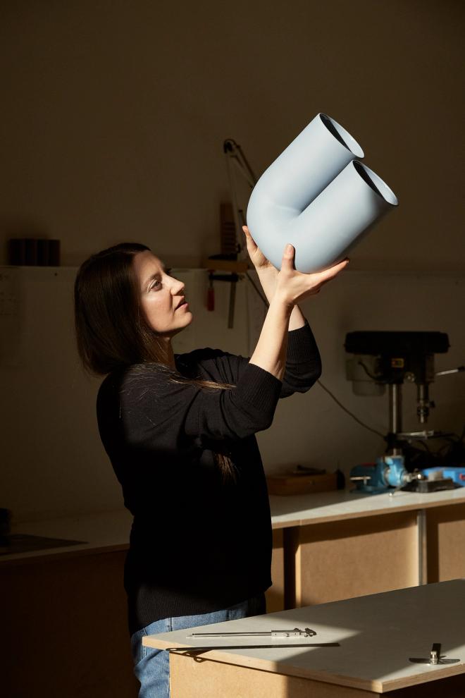 Rachel Griffin looking at her design, the Kink vase.