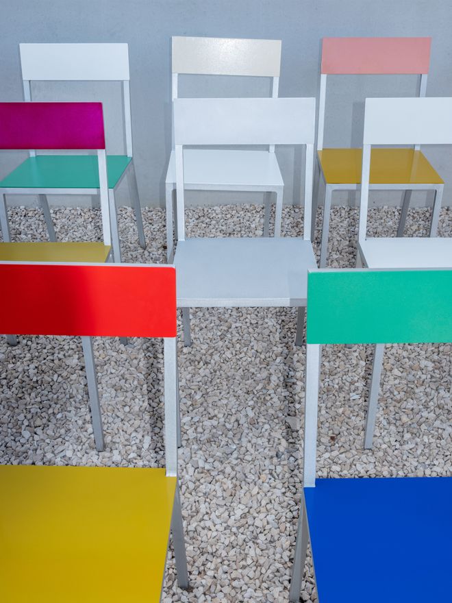 A collection of valerie_objects’ Alu chairs in different colours on gravel
