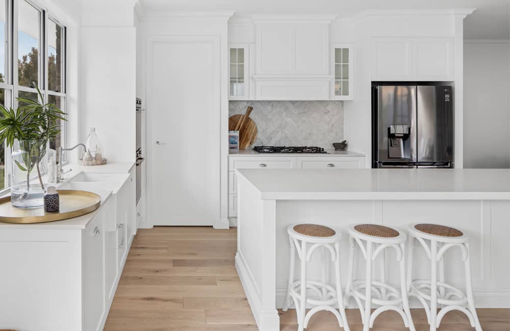 Beautiful Bingara (All-white shaker kitchen with island, wicker stools and herringbone marble splashback)