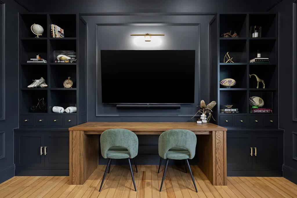 Project Franklin (Dark media room with wall-mounted TV and wood desk.)