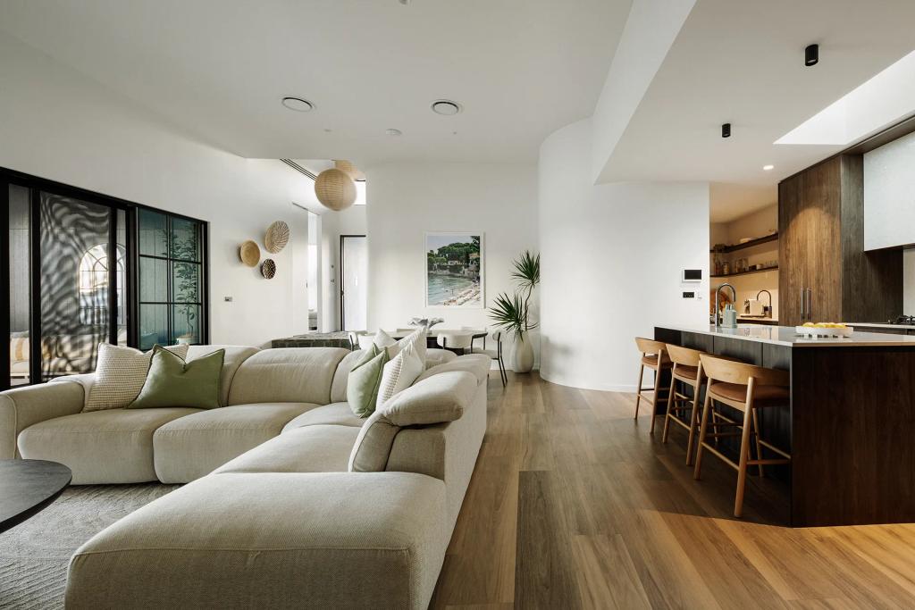 Lavish Morada (Bright open-plan living area with neutral sectional, wood kitchen, and natural decorative touches.)