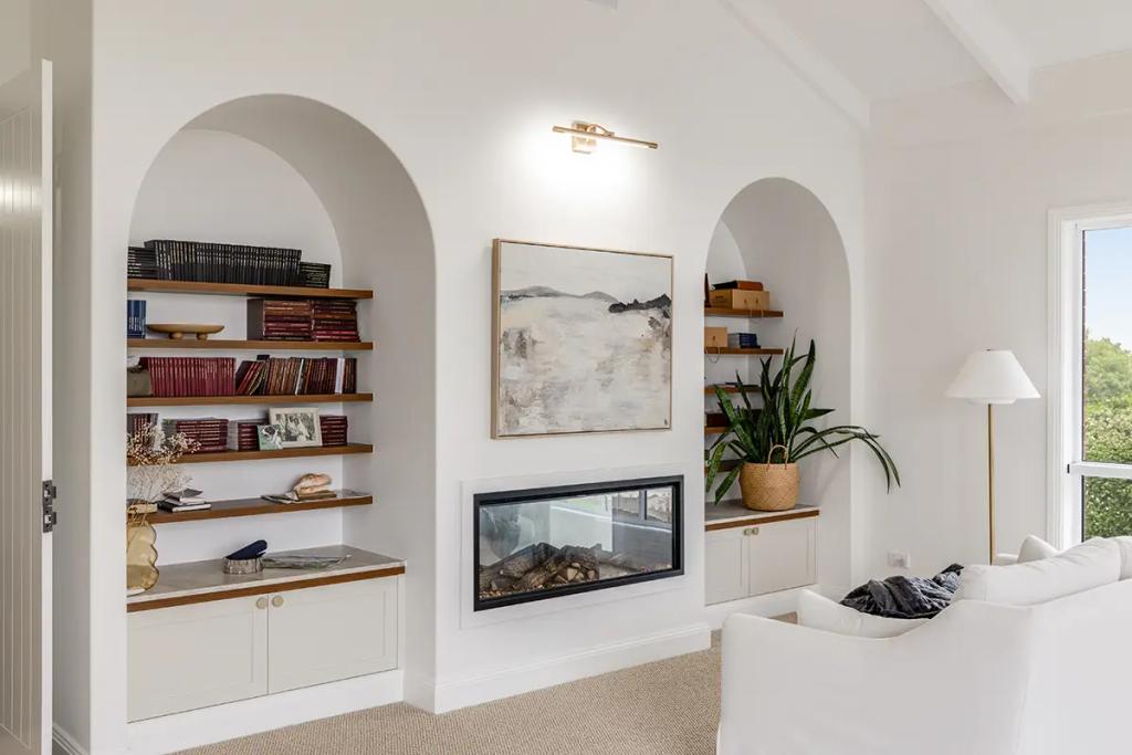 Hodgsonvale House Renovation (A cozy living room with a fireplace, arched built-in shelves, and a white sofa.)