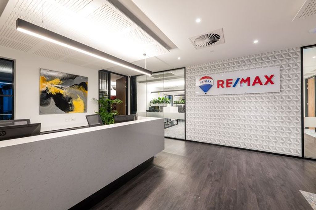 Project RE/MAX (Remax white Front Desk with Remax logo on the wall)
