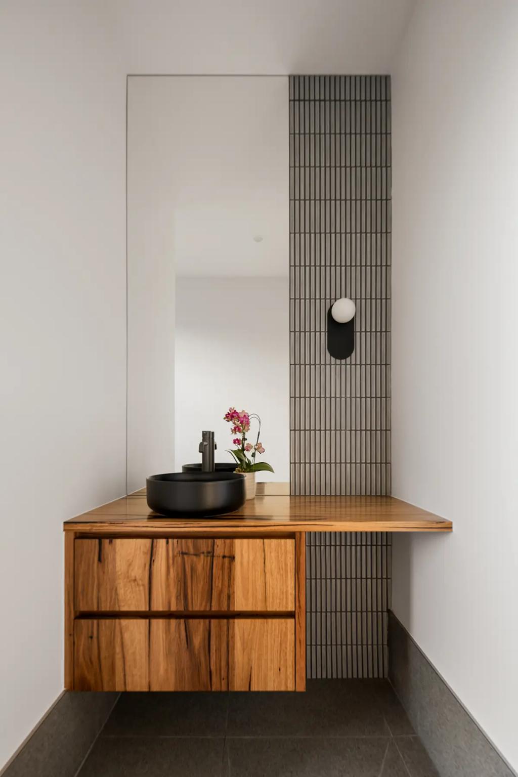 Project Treevue (modern bathroom with a wooden vanity and black countertop sink with a wall-mounted mirror)