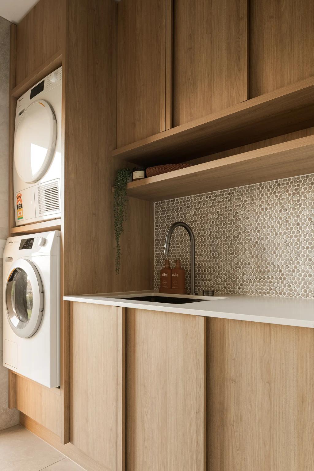 Project Mount Rascal (Modern laundry room with wooden cabinets, stacked washer and dryer, sink, and penny tile backsplash)