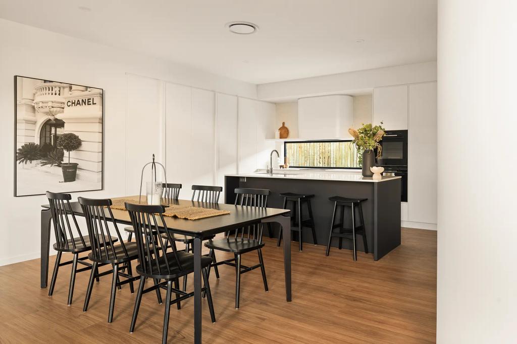 Project Ward (Modern kitchen and dining area with black chairs, a Chanel print, and a white island with black stools)
