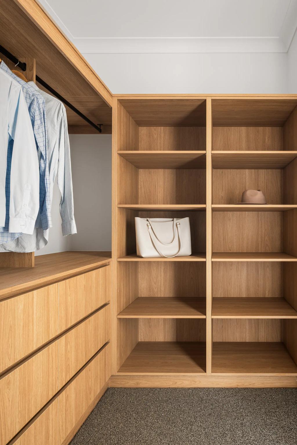 Project Ward (Walk-in closet with wooden shelves, hanging shirts, a white handbag, and a hat on the shelves)