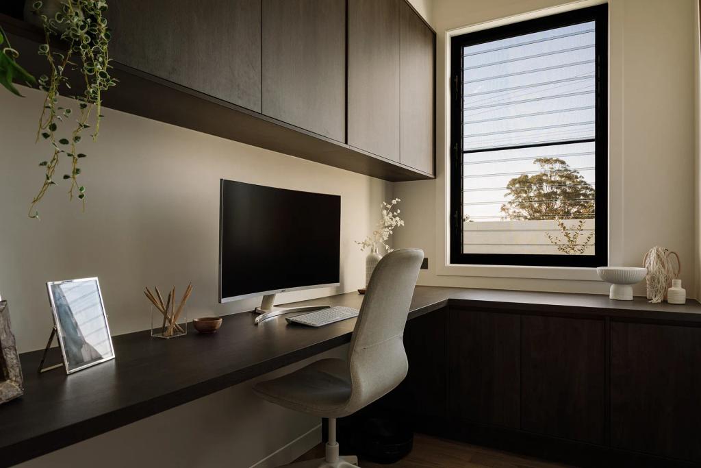 Lavish Morada (Minimalist home office with dark wood cabinetry, monitor setup, and large window view.)