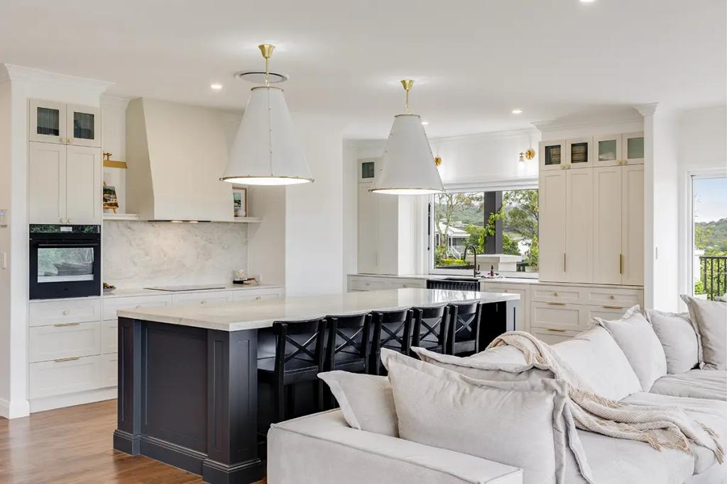 Hodgsonvale House Renovation (A luxurious open-plan kitchen and living room with white and dark wood cabinetry.)