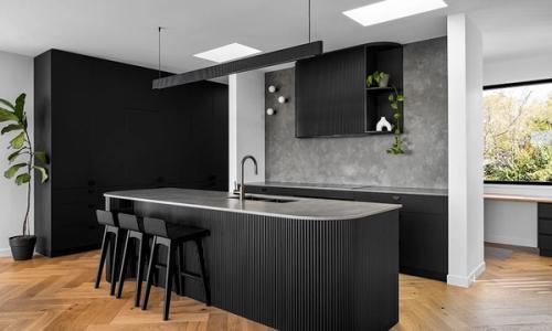 Our Lady McQueen (Black slatted island with grey stone benchtop, matte black cabinetry and herringbone floors)