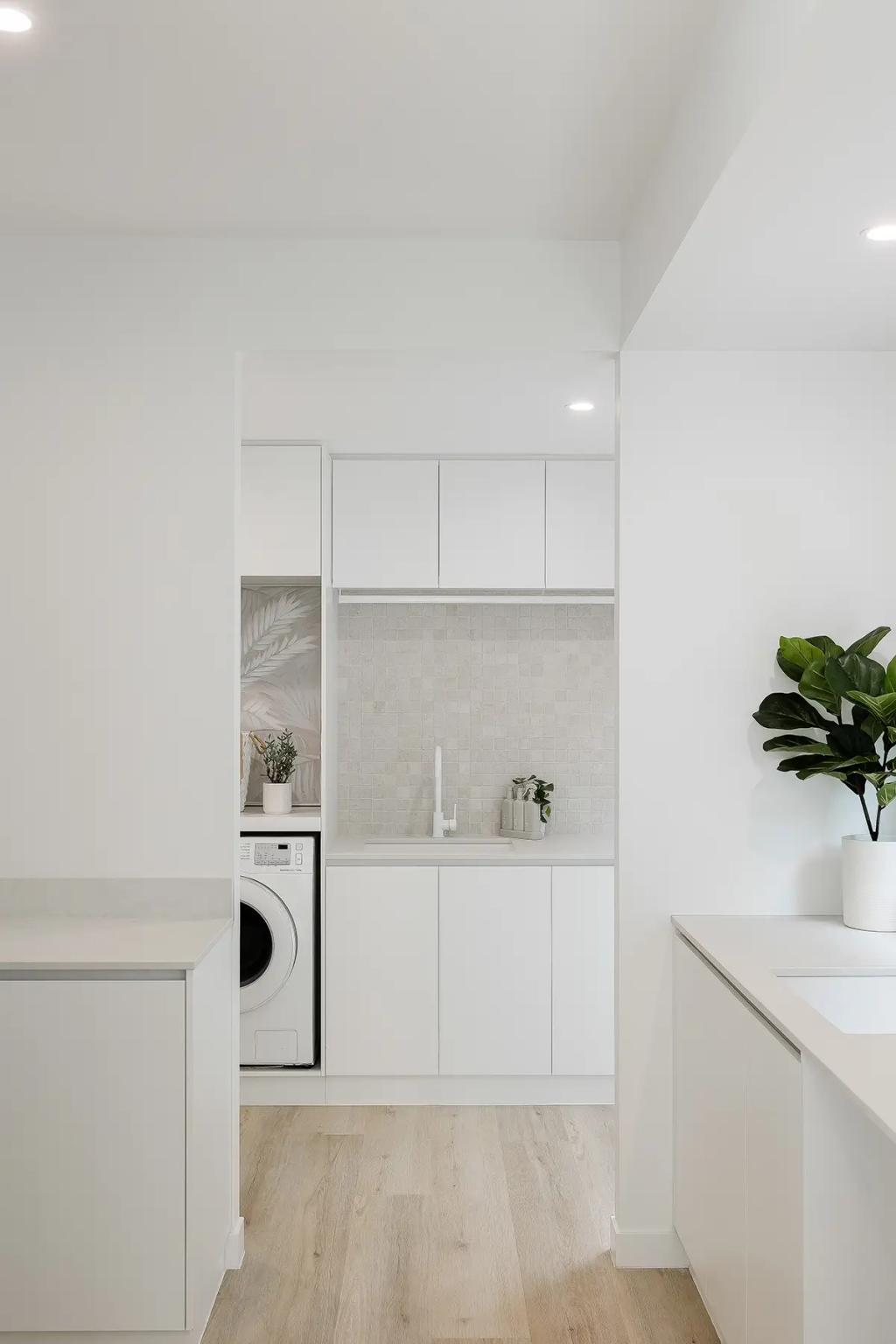 Project Vuse (A minimalist laundry room with white cabinets, a washing machine, and a plant on the counter)