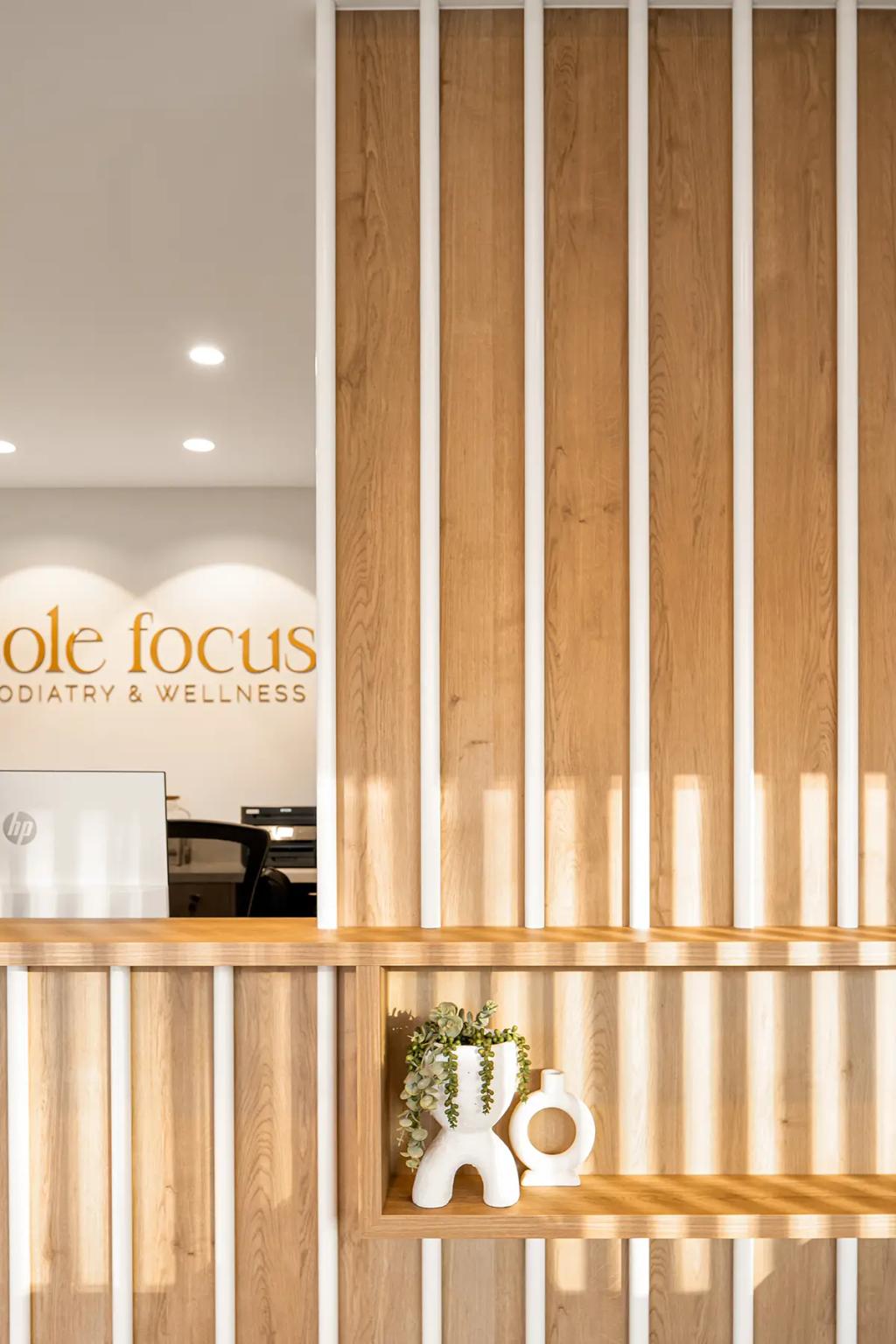 Lavish Constructions - Sole Podiatry (Wood-panel detail with decor near reception counter.)