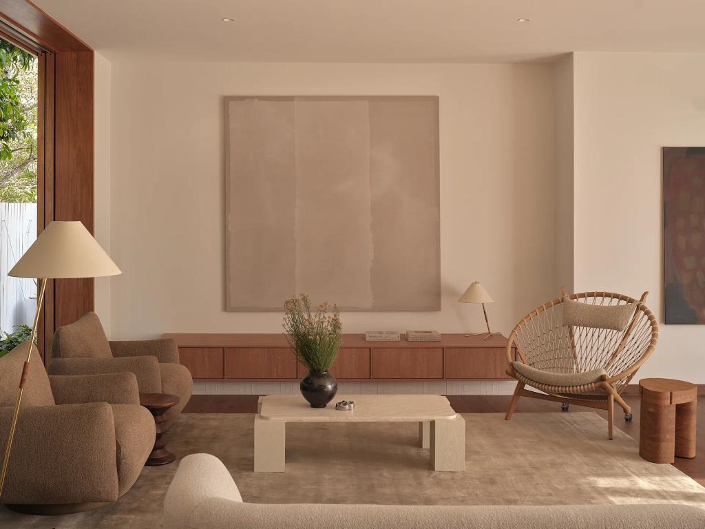 Project Riverton (Contemporary living room in neutral tones with modern art, curved sofa, and a woven armchair.)