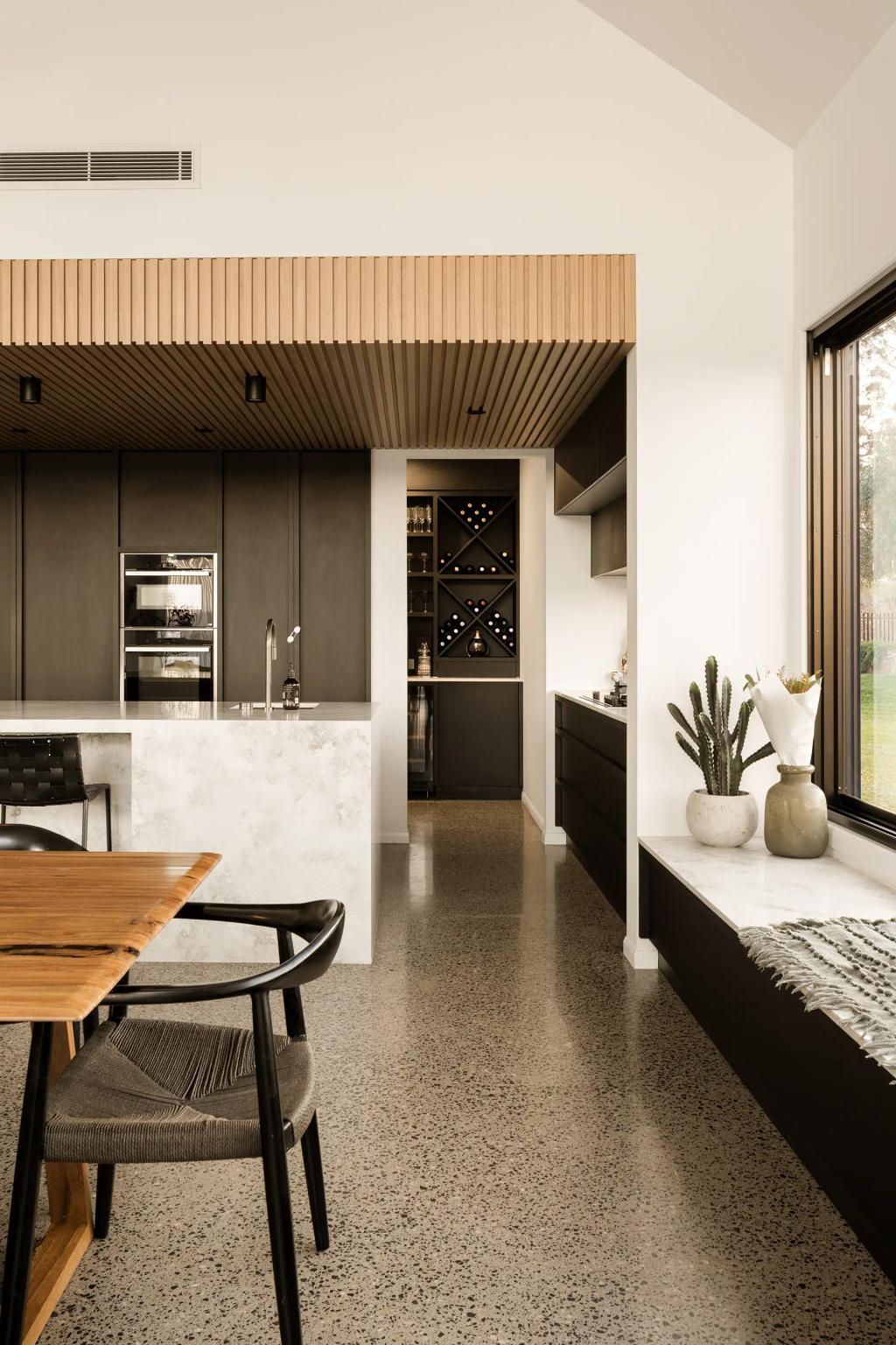 Project Mount Rascal (Modern kitchen with black cabinets, marble island, wine storage, and large window with plants)