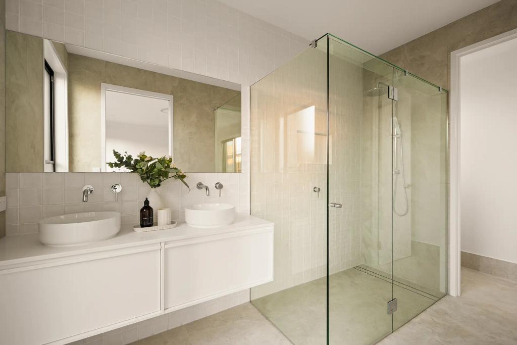 Project Ward (Modern bathroom with dual sinks, large mirror, glass-enclosed shower, and a vase with greenery on the counter)