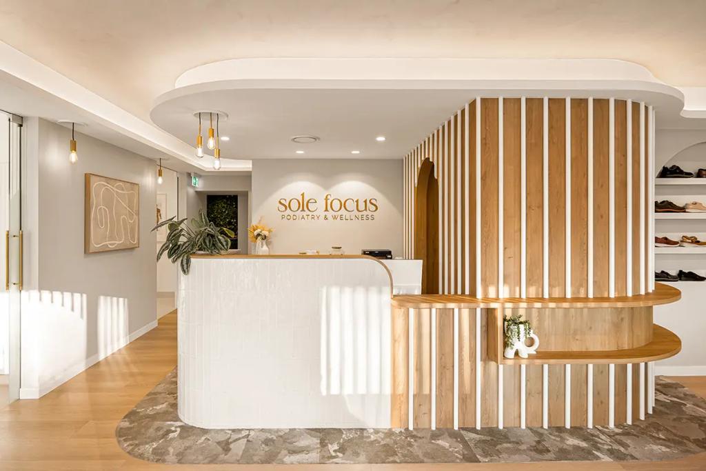 Curved reception desk at Sole Focus with warm lighting.