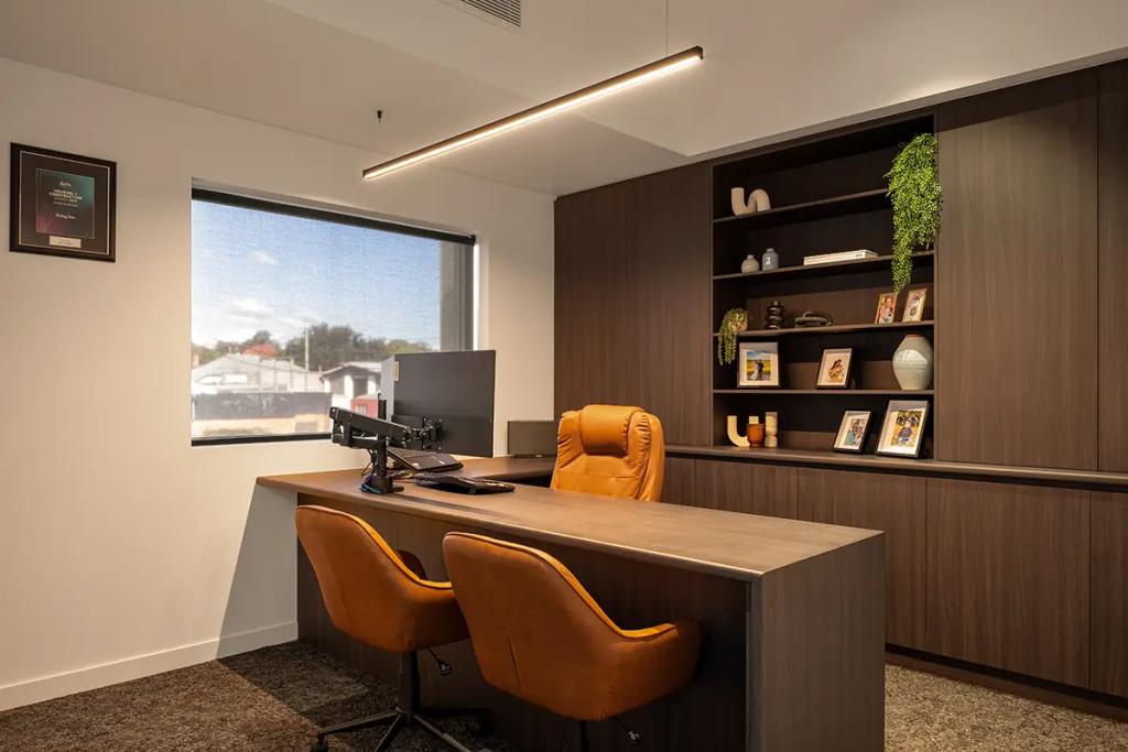 Executive office with brown chairs and wall shelving