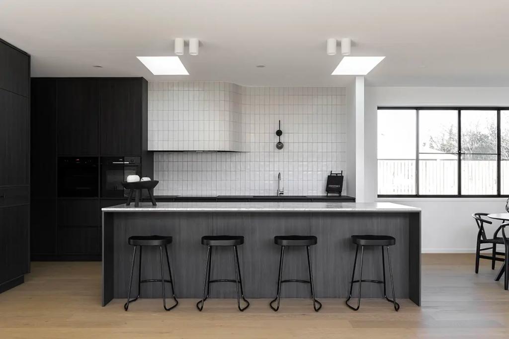 Project Ward 2.0 (Contemporary kitchen with dark wood cabinets, a marble island, black stools, and white tiled walls)