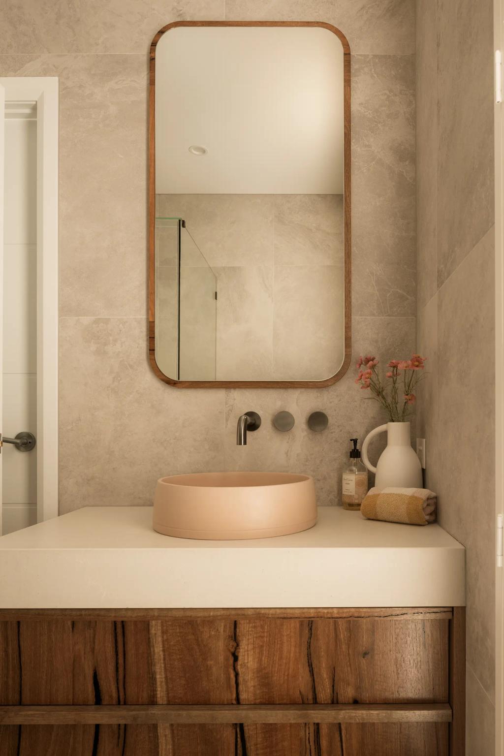 Project Mount Rascal (Modern bathroom with wooden vanity, beige round sink, large mirror, and decorative flowers in a vase)