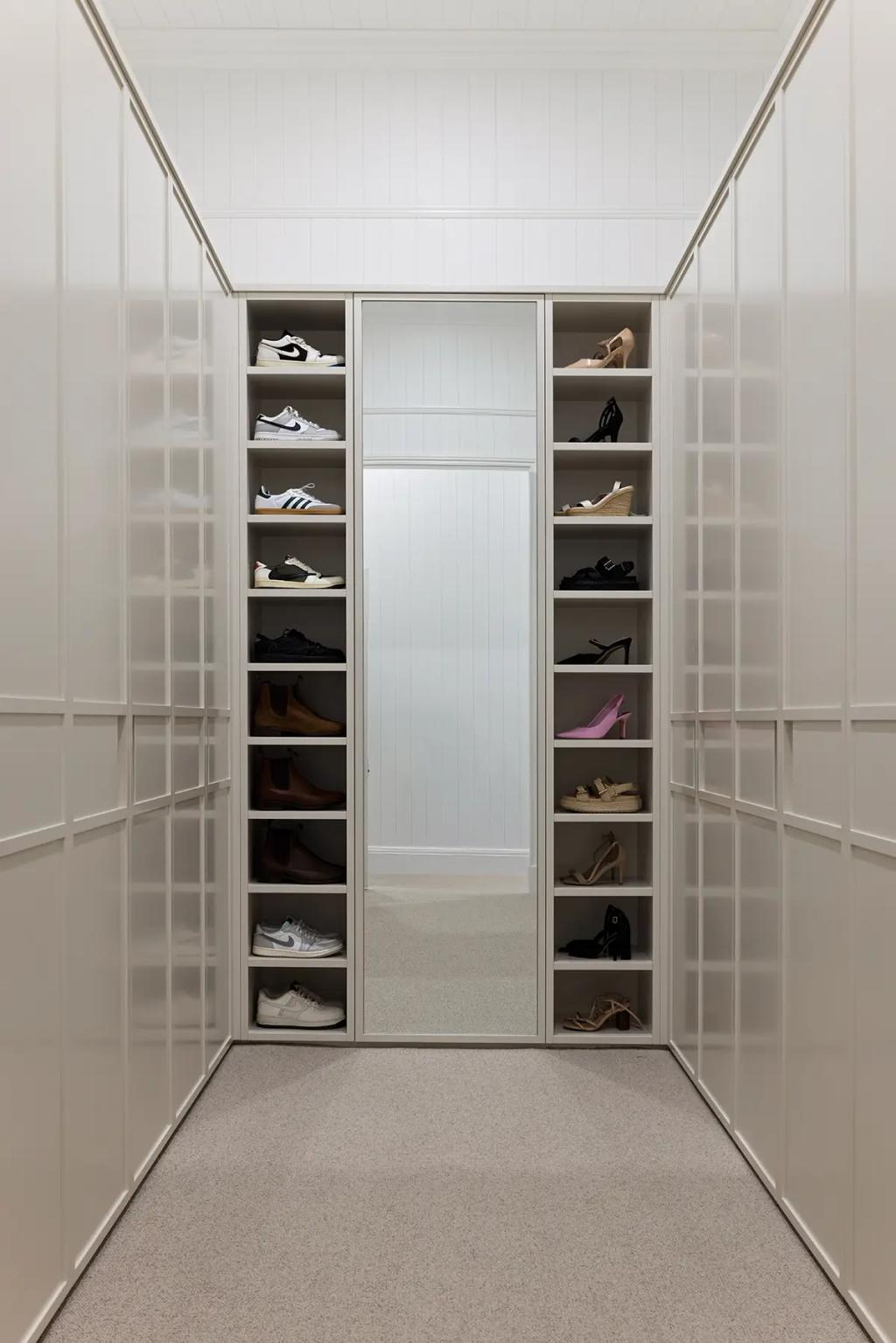 Project Franklin (Walk-in wardrobe with open shelving displaying an assortment of neatly arranged shoes on both sides.)