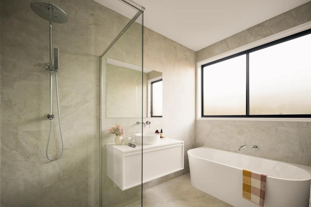 Project Ward (Modern bathroom with a glass-enclosed shower, white vanity, freestanding bathtub, and large window)