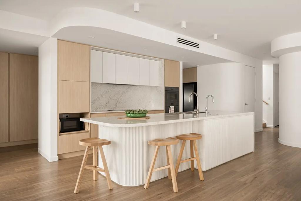 Cheltenham (Curved white island in bright wood-accented kitchen)