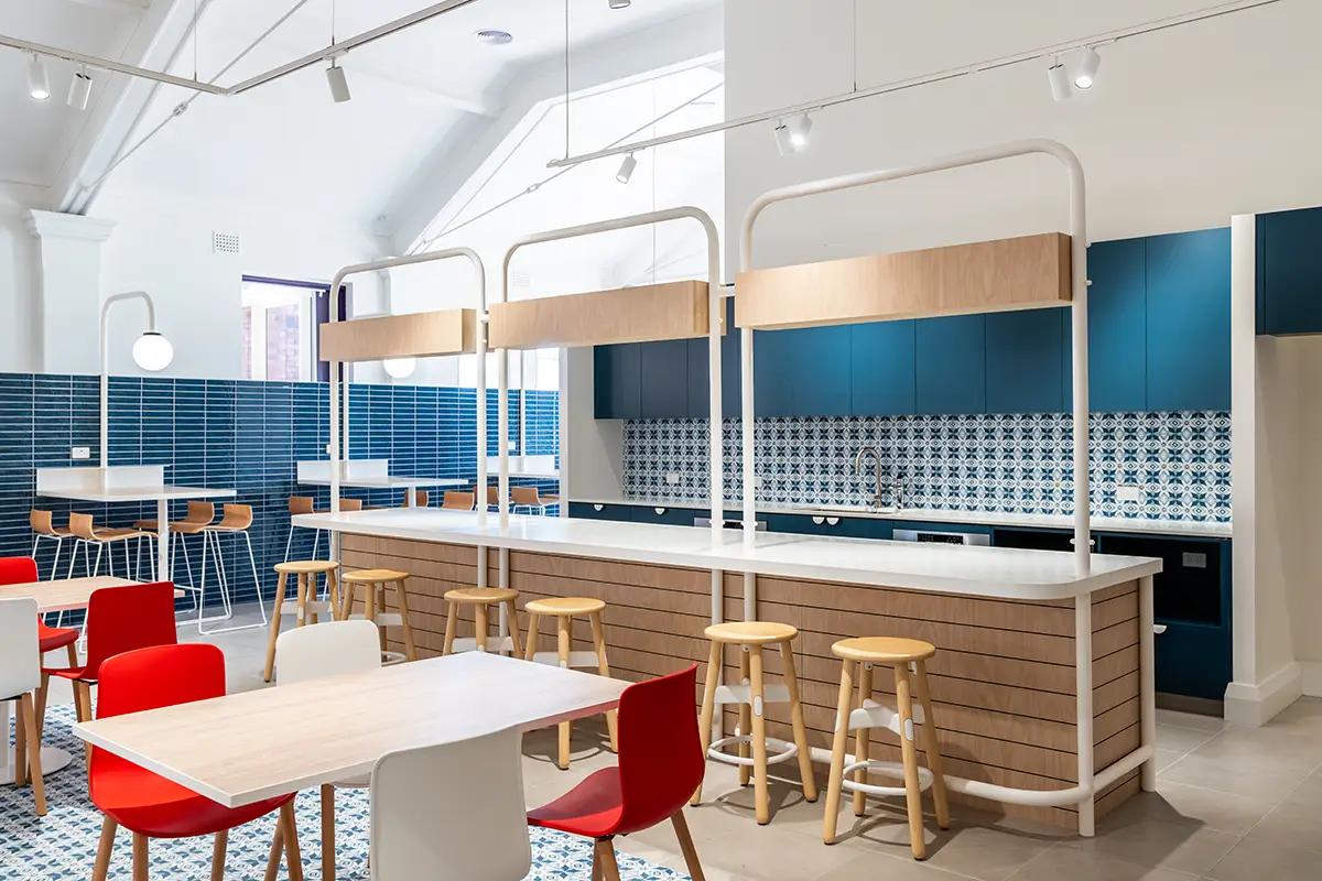 Downlands College Toowoomba Refurbishment (Cafe joinery with timber-slat counter, teal cabinetry and blue-and-white patterned tiles)