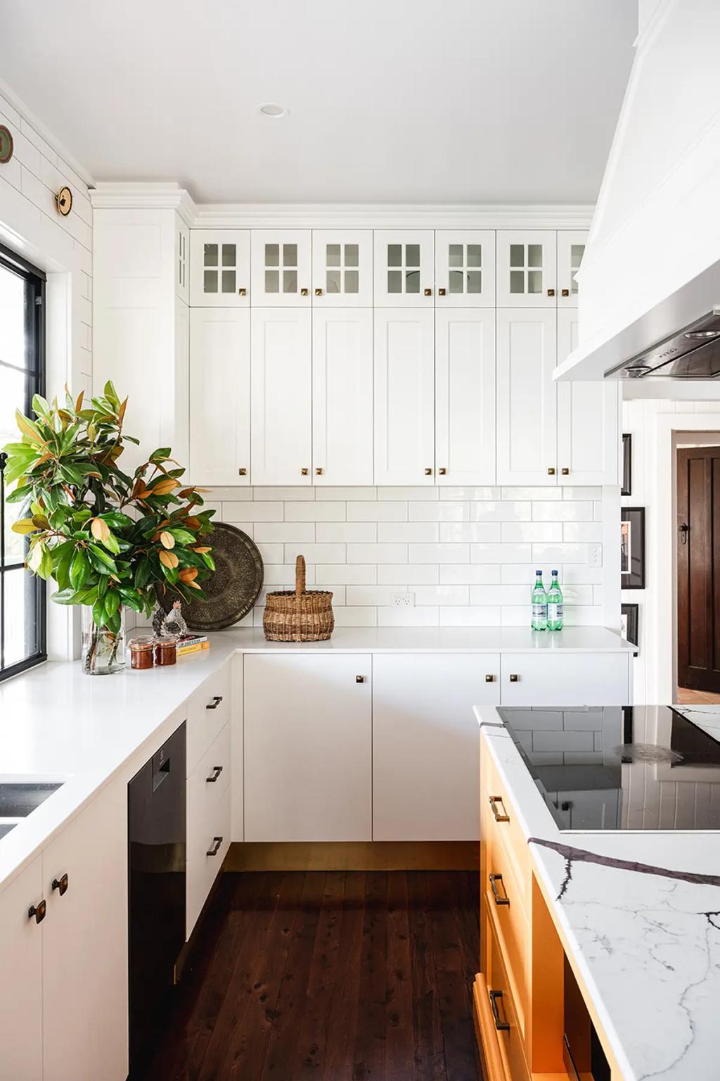 Project Coral Sea (Modern kitchen with white cabinets, subway tile backsplash, yellow island, and a large green plant)