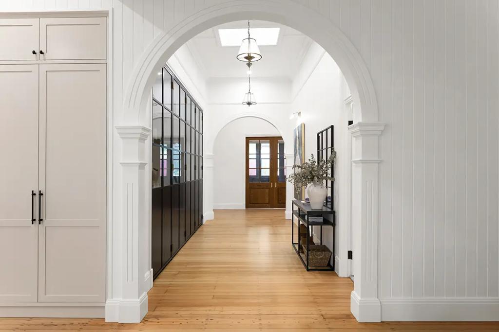 Project Franklin (Arched hallway with wood floors and glass cabinets.)